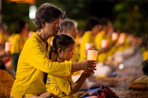 法轮功学员在台北市政府广场前举办反迫害21周年烛光悼念活动。